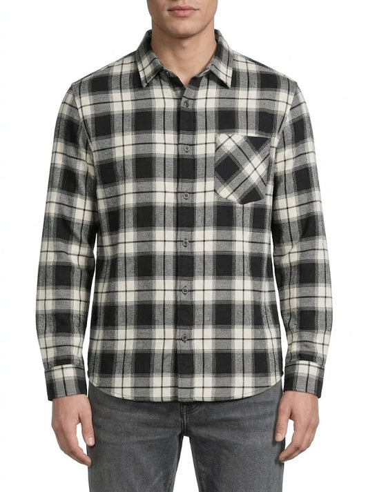 A man wearing a long-sleeve button-up plaid shirt in black, white, and gray, paired with gray jeans, against a plain white background.