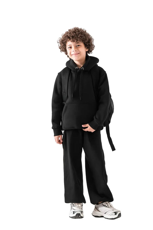 Front view of a boy wearing wide leg summer milton black cotton-lycra sweatpants by TREE.