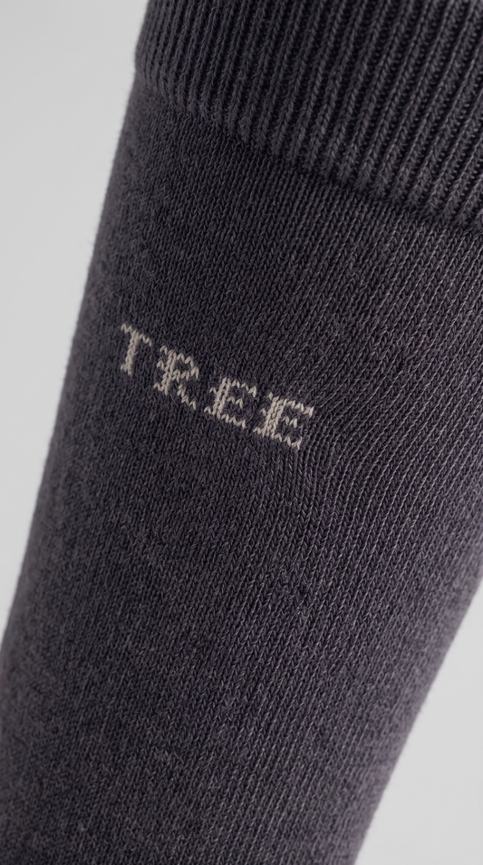 A single dark gray crew sock with the brand name 'TREE' printed in white on the side, displayed on a light gray background.