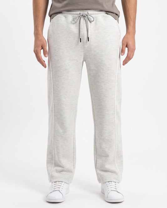 Front view of a man wearing wide-leg sweatpants in light grey by TREE.