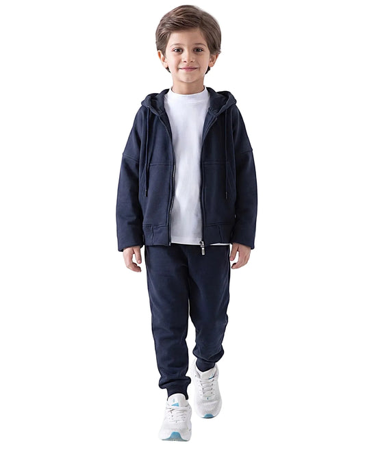 Boy modeling an open dark navy kids' oversized milton zip hoodie over a white t-shirt, with matching sweatpants by TREE