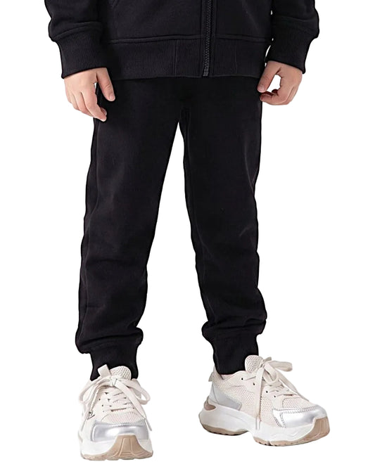 Side view of a young girl wearing black milton pants in a relaxed fit by TREE.