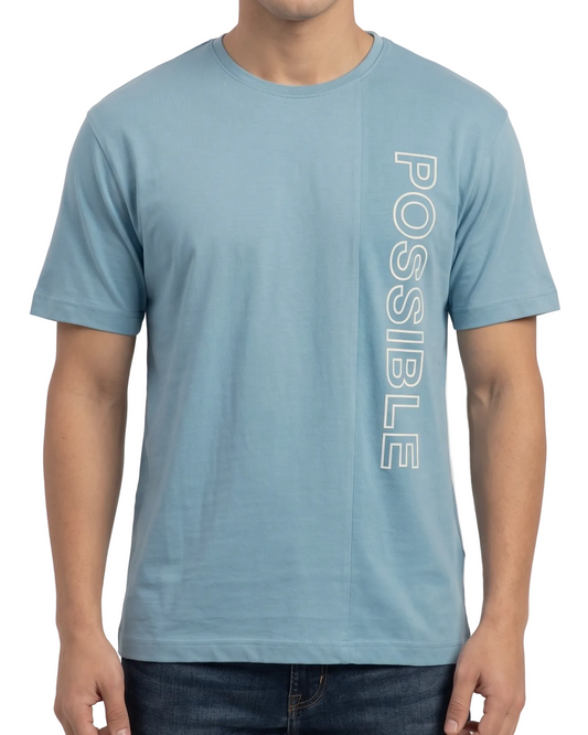 Person wearing a blue t-shirt with 'POSSIBLE' text on a plain background