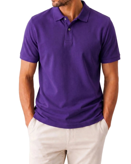 A man wearing a short-sleeve purple polo shirt and light beige pants, shown from the chin down against a plain white background.