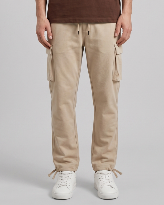 Person wearing beige cargo pants with a plain background
