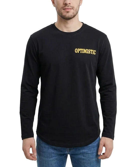 A man wearing a black long-sleeve t-shirt with 'OPTIMISTIC' printed in yellow across the chest, paired with blue jeans, against a plain light gray background.