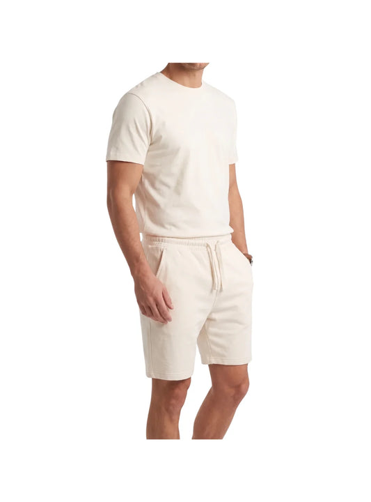 Man wearing a relaxed fit beige cotton short pajama set from TREE, showing the back and fit details.
