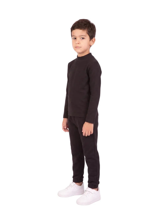 Front view of a young boy wearing a black long-sleeve high-neck basic top by TREE