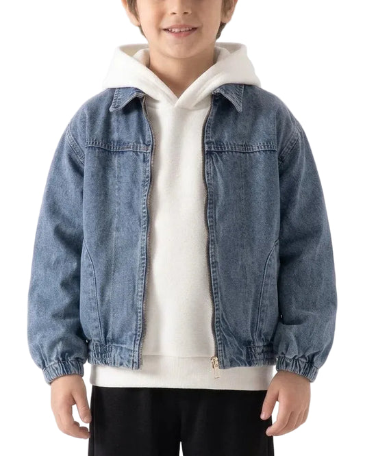 A child wearing a light blue denim jacket over a cream-colored zip-up hoodie and black pants, photographed against a plain light background.