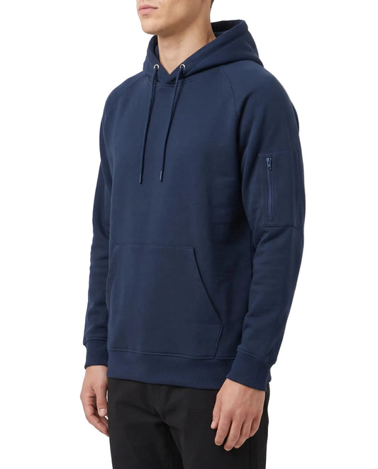 A man wearing a navy blue pullover hoodie with a front kangaroo pocket, drawstrings, and a zippered sleeve pocket, shown from the side against a plain white studio background.