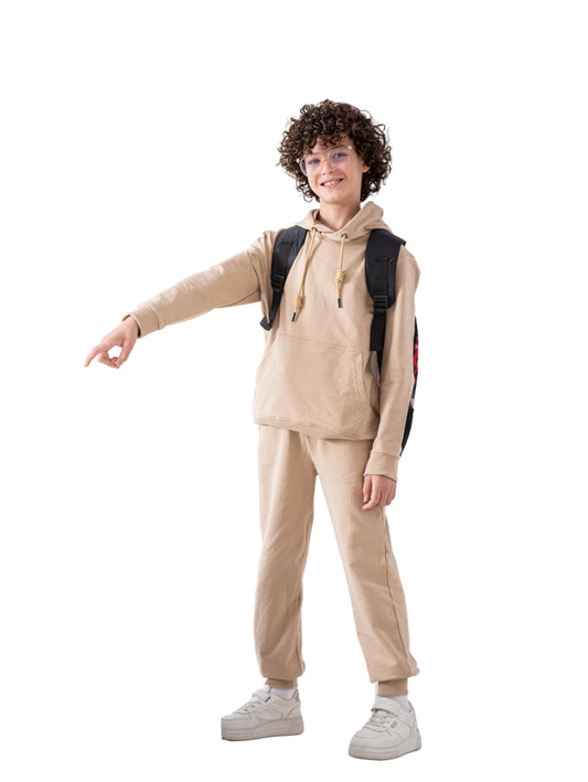 Person in beige hoodie and pants with a backpack standing next to books and lockers.