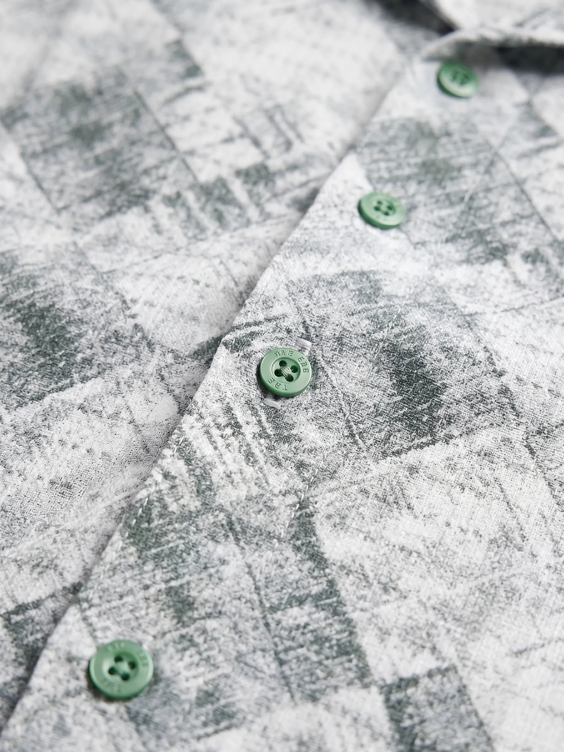 Front view of a man wearing a short-sleeve revere collar printed shirt by TREE.