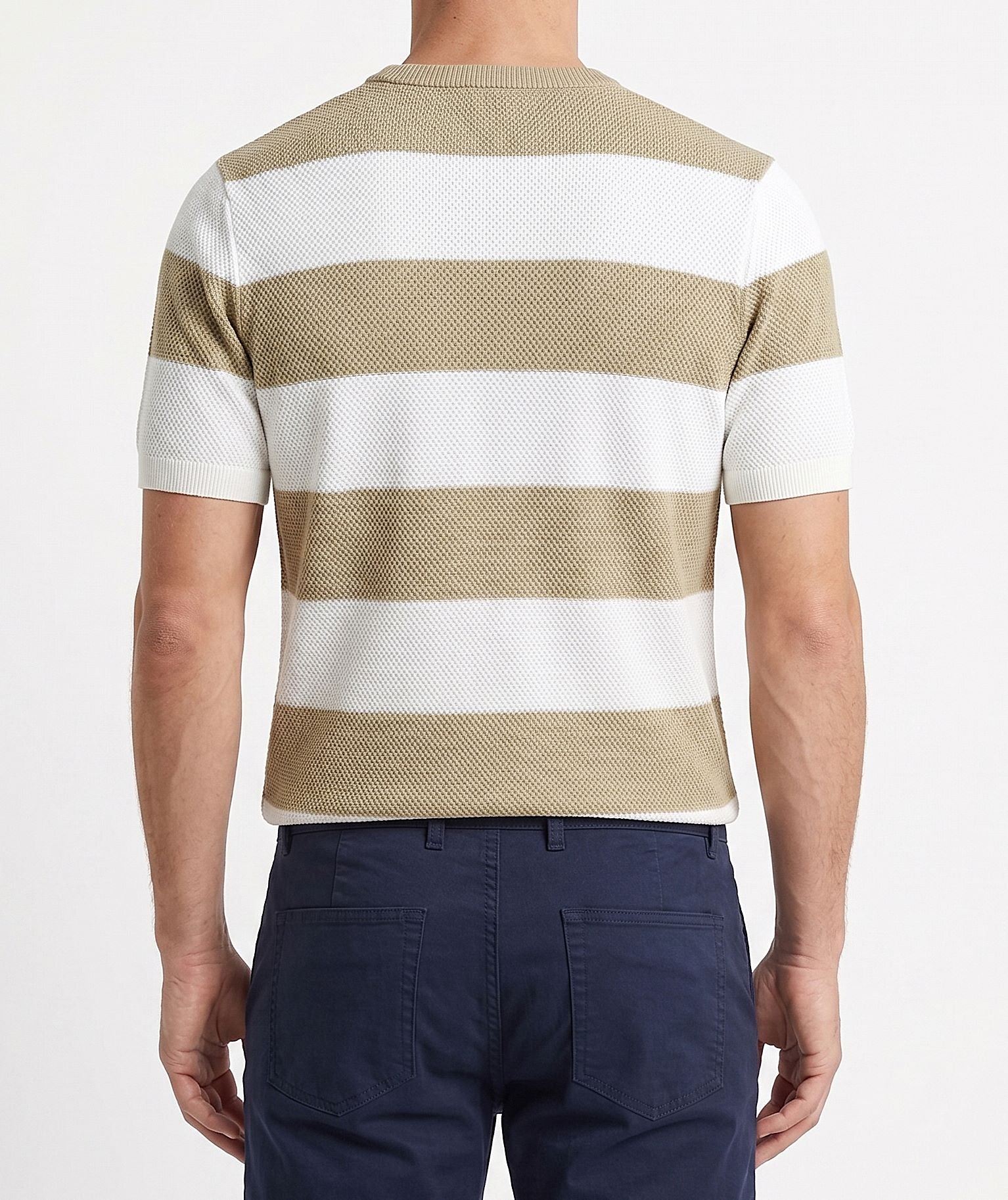 A man wearing a summer horizontal striped knit t-shirt with a textured finish and crew neck, paired with casual pants.