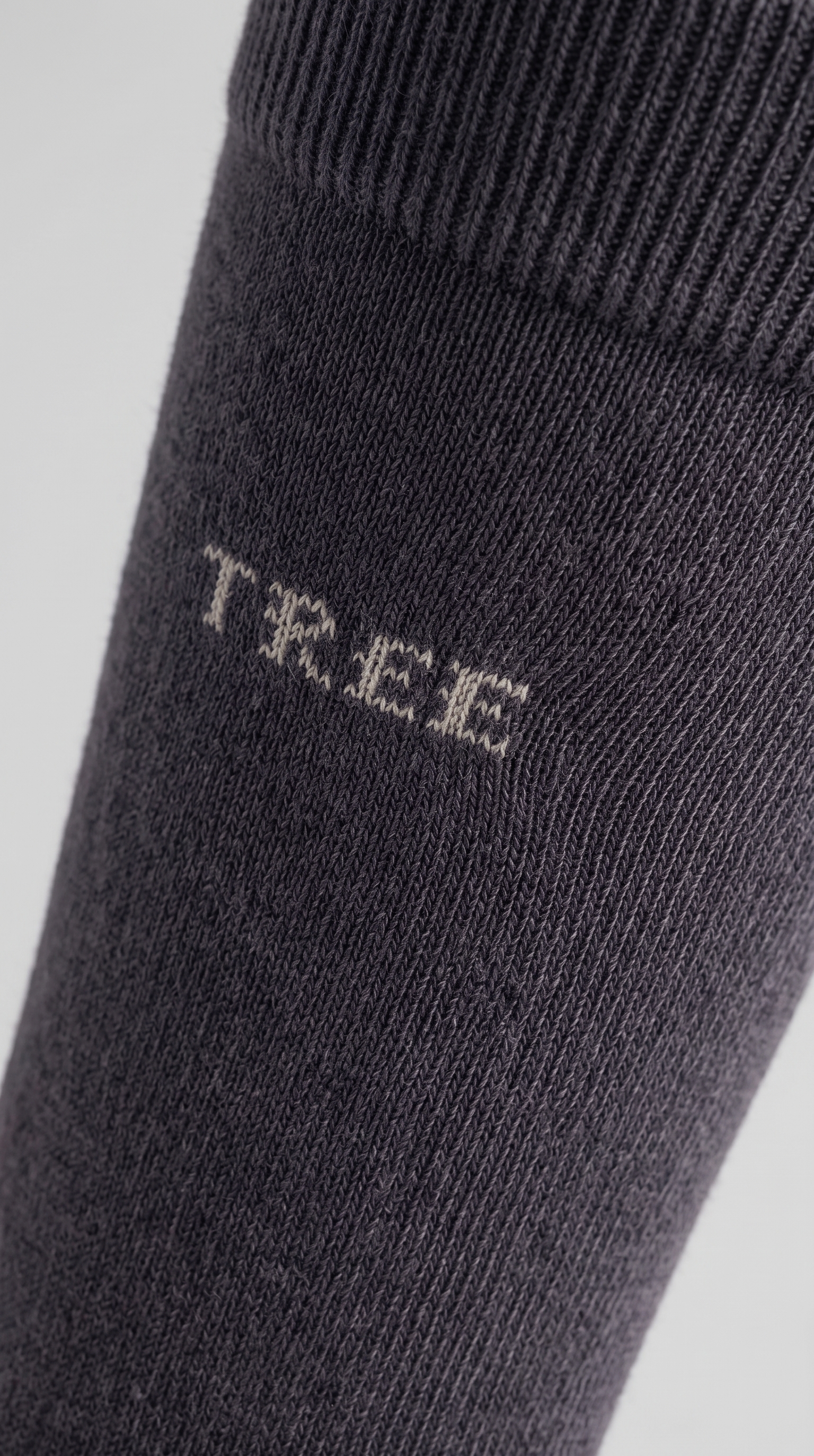 A single dark gray crew sock with the brand name 'TREE' printed in white on the side, displayed on a light gray background.