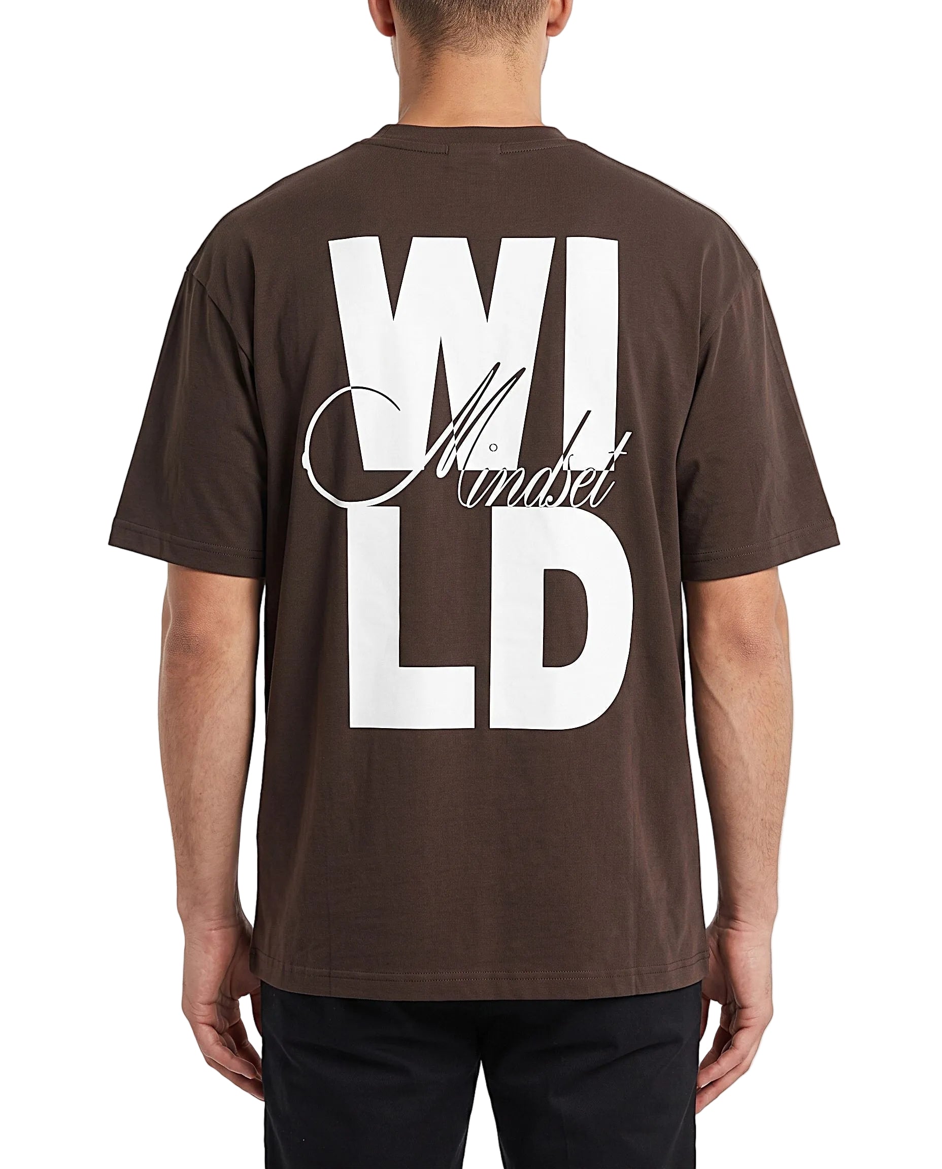 A man viewed from the back wearing a dark brown t-shirt with a large white graphic print reading 'WILD Mindset' on the back, paired with black pants against a clean white background.
