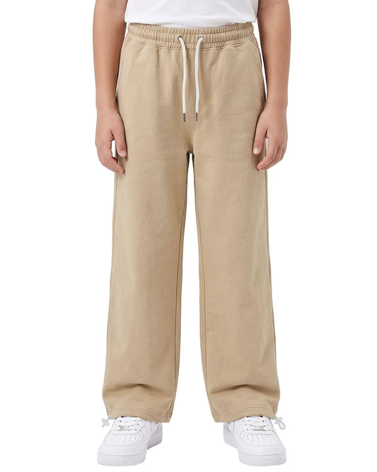 Front view of a boy wearing beige summer milton wide-leg sweatpants with side pockets and a drawstring waist by TREE.