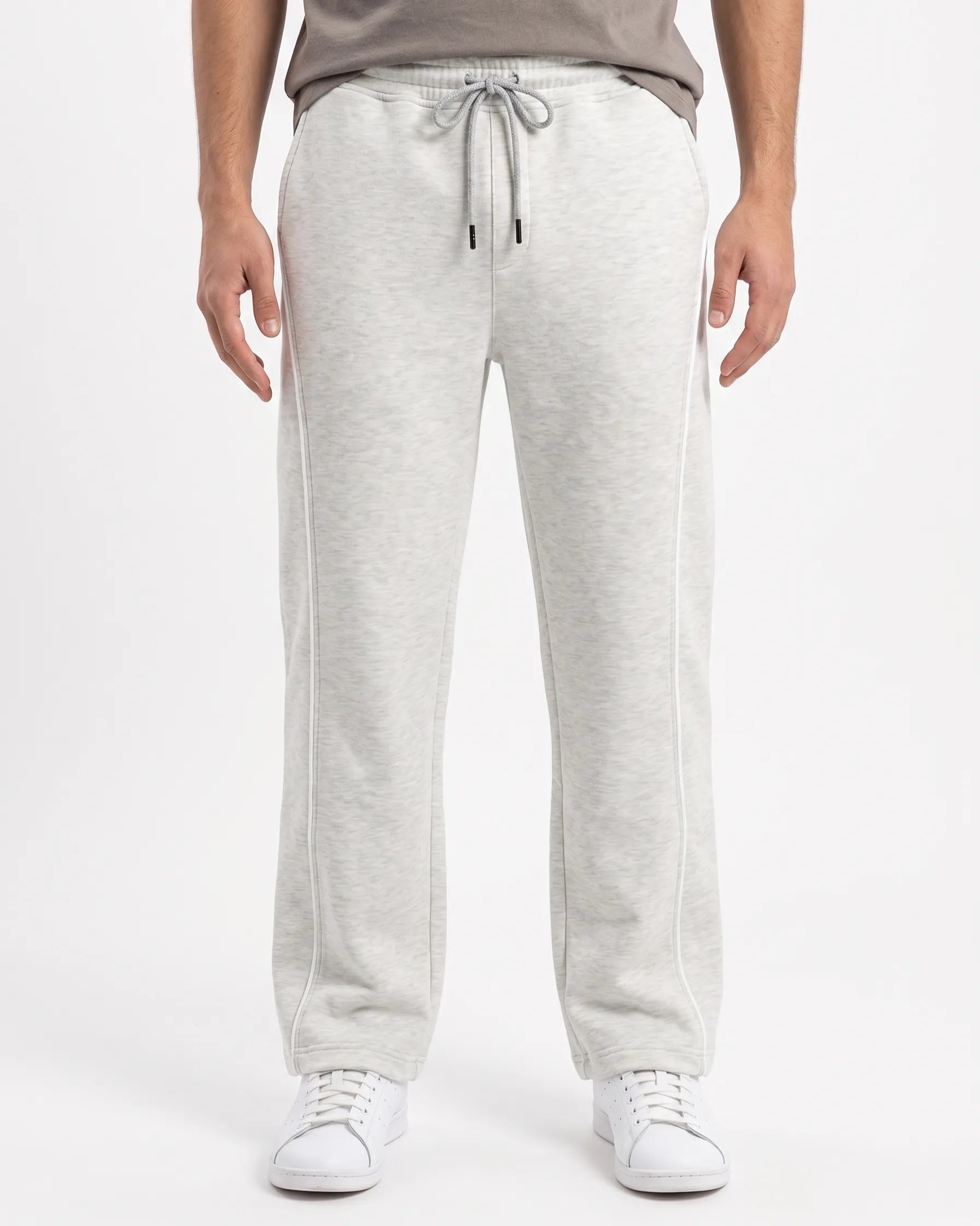 Front view of a man wearing wide-leg sweatpants in light grey by TREE.