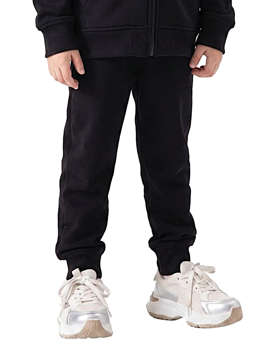 Side view of a young girl wearing black milton pants in a relaxed fit by TREE.