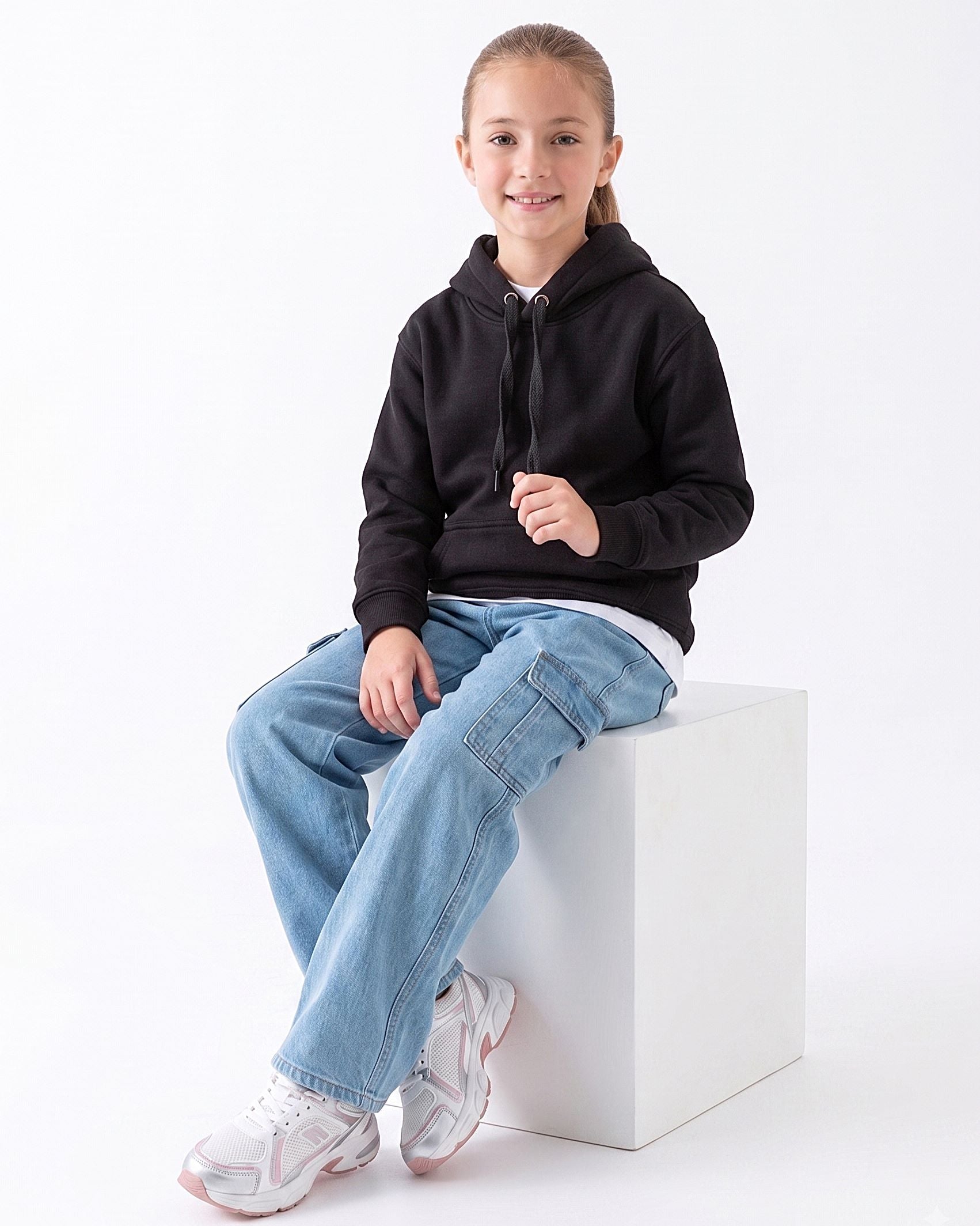 Front view of a young girl wearing a black milton hoodie in a relaxed fit by TREE.