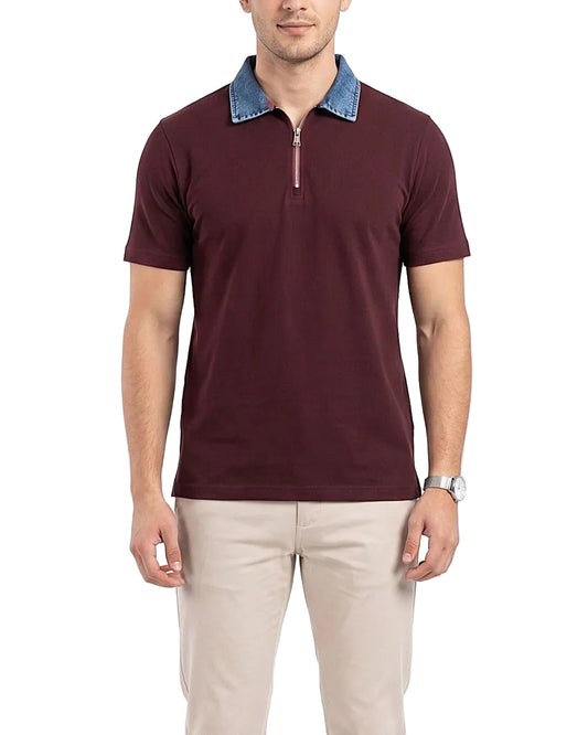 Detailed front shot of the model wearing the burgundy polo with a denim collar and beige trousers