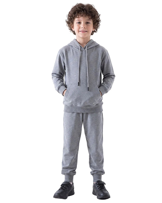 Boy modeling a Boys' Solid Grey Summer Milton Hoodie with hands in the front kangaroo pocket, paired with matching sweatpants and black sneakers.