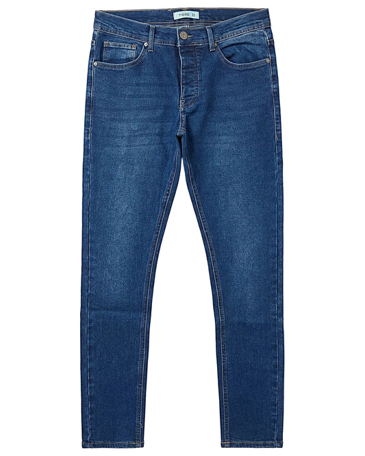Front view of a model wearing men's slim fit jeans in a classic wash by TREE.
