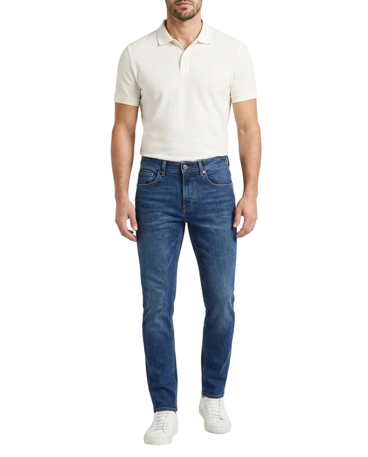 Front view of a man wearing dark blue slim fit jeans by TREE.
