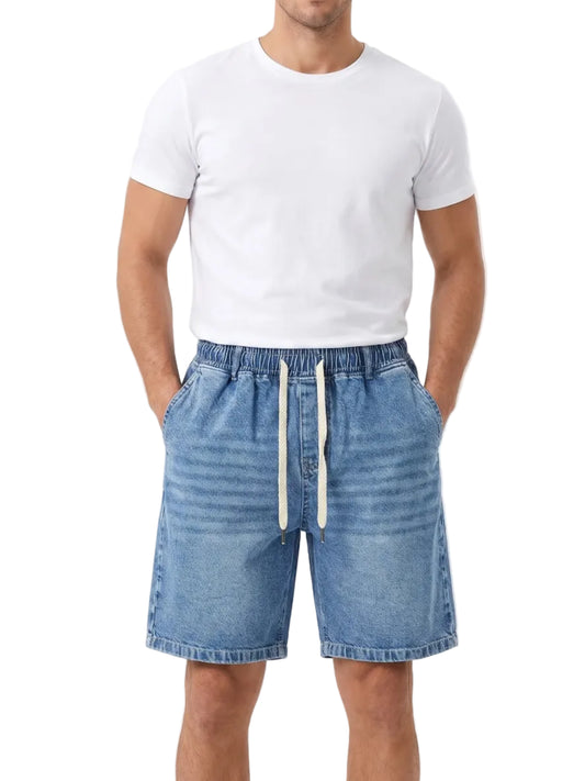 Front view of a man wearing oversized denim shorts by TREE.