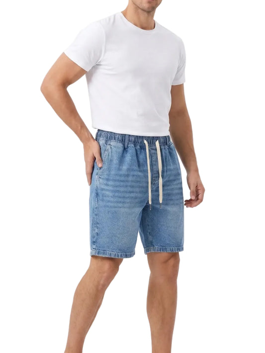 Front view of a man wearing oversized denim shorts by TREE.