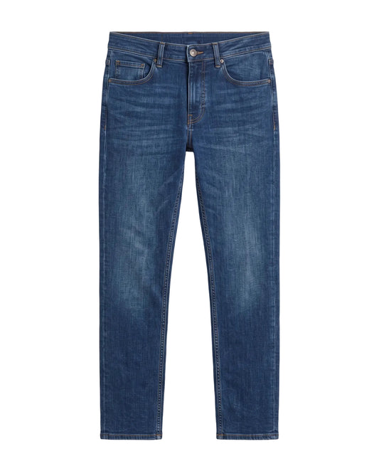 Front view of a man wearing dark blue slim fit jeans by TREE.