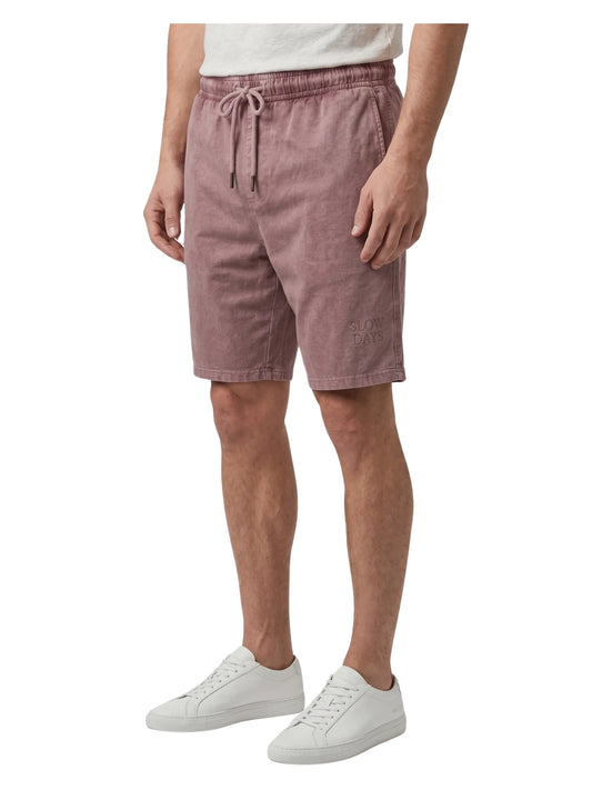Front view of a man wearing faded burgundy casual summer shorts with an elastic drawstring waist by TREE
