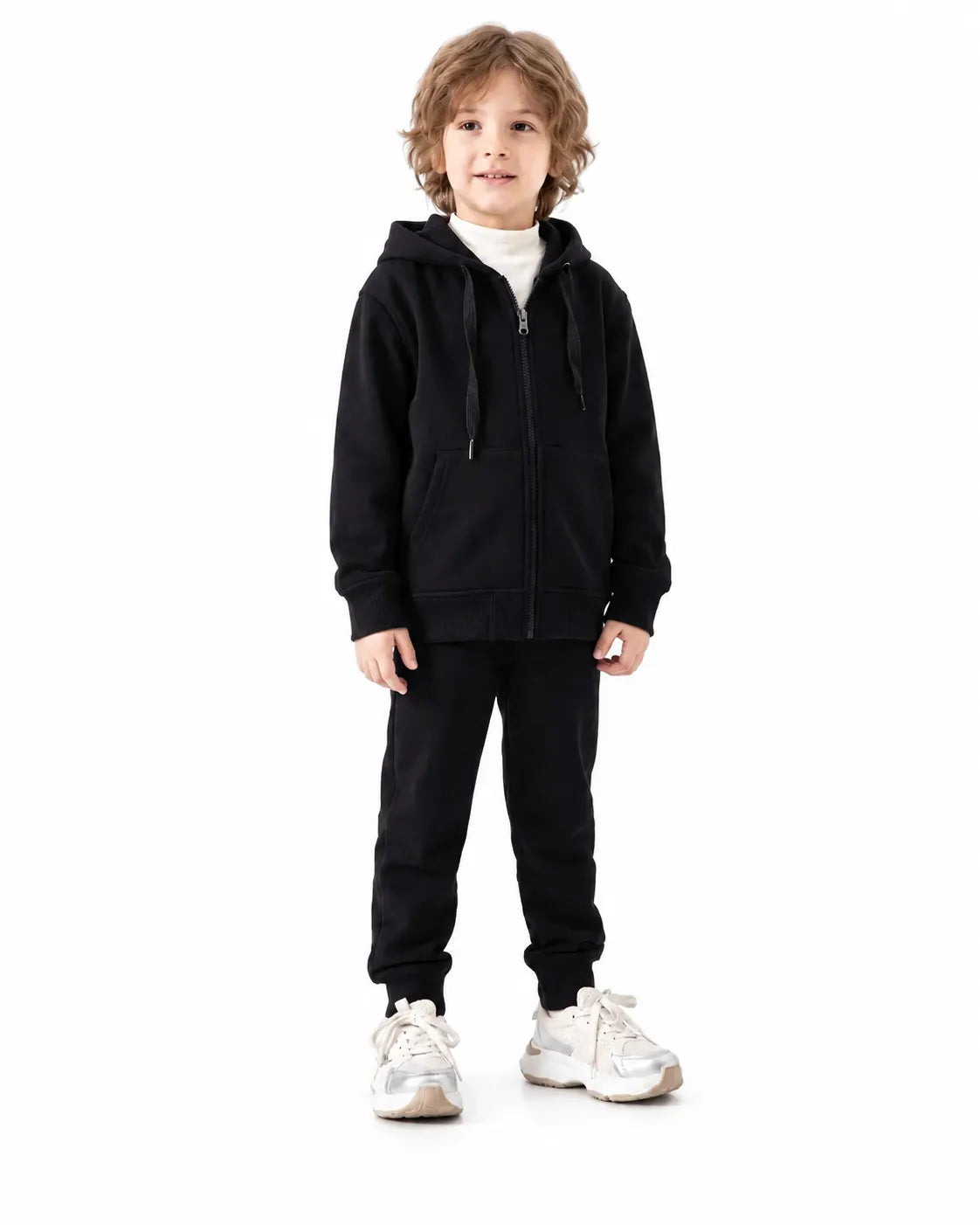 Front view of a boy wearing black milton winter sweatpants paired with a matching zip hoodie by TREE.