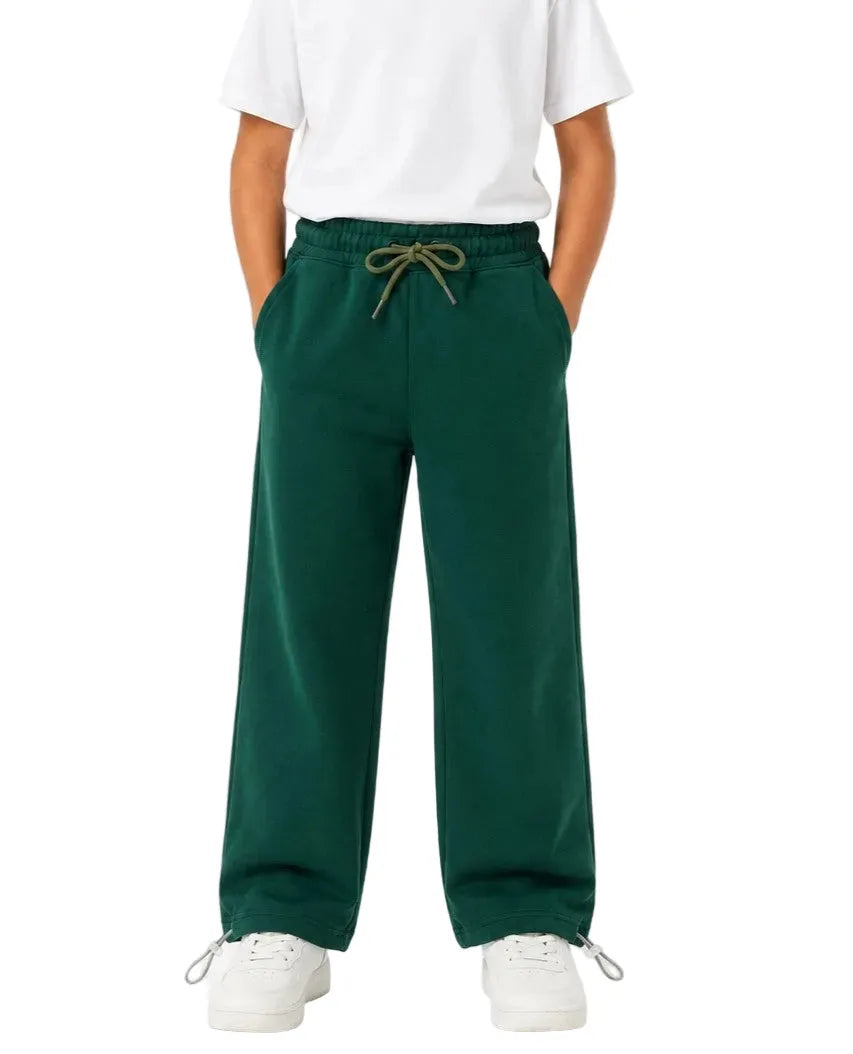 Multiple views of a boy wearing dark green summer milton wide-leg sweatpants with side pockets and a drawstring waist by TREE.