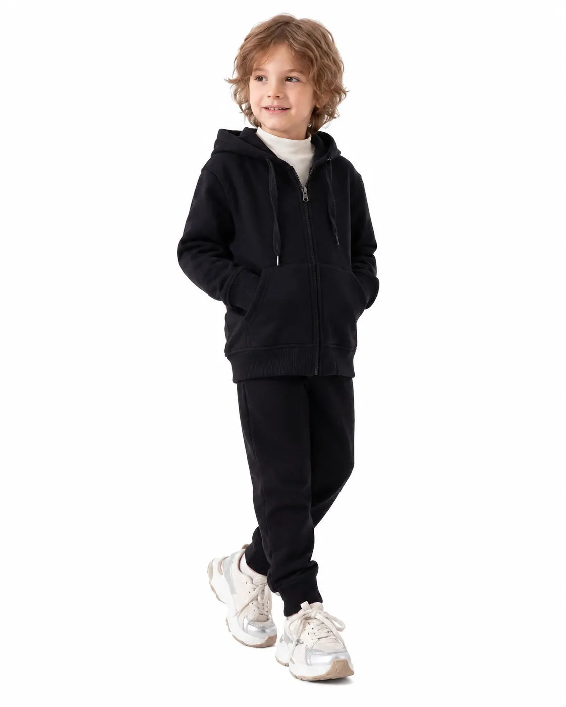 Front view of a boy wearing black milton winter sweatpants paired with a matching zip hoodie by TREE.