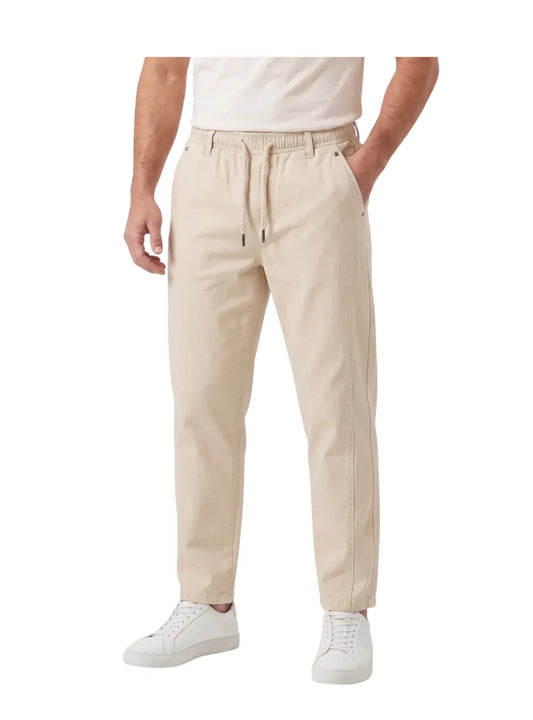 Front view of a man wearing beige wide-leg gabardine sarouel pants by TREE