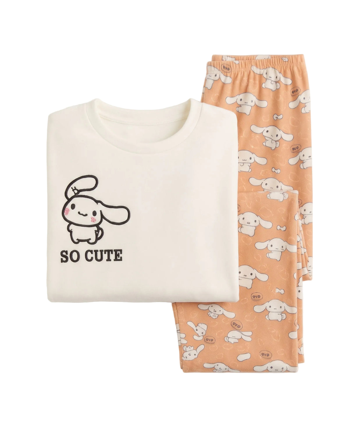 A folded two-piece pajama set on a white background, featuring an off-white short-sleeve top with a black cartoon bunny graphic and the text 'SO CUTE' next to peach-colored pants with an all-over cartoon bunny print.