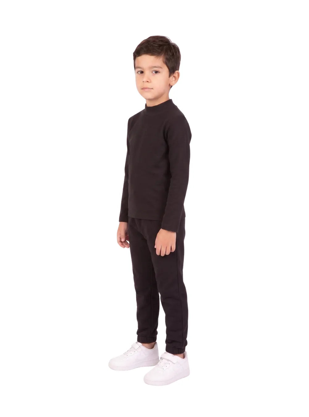 Front view of a young boy wearing a black long-sleeve high-neck basic top by TREE