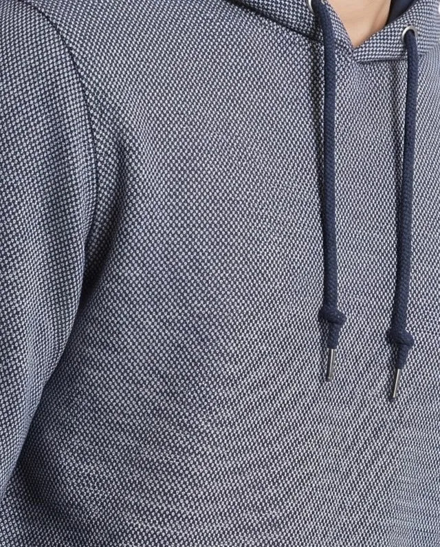 Close-up of a textured gray hooded sweatshirt with dark navy drawstrings.