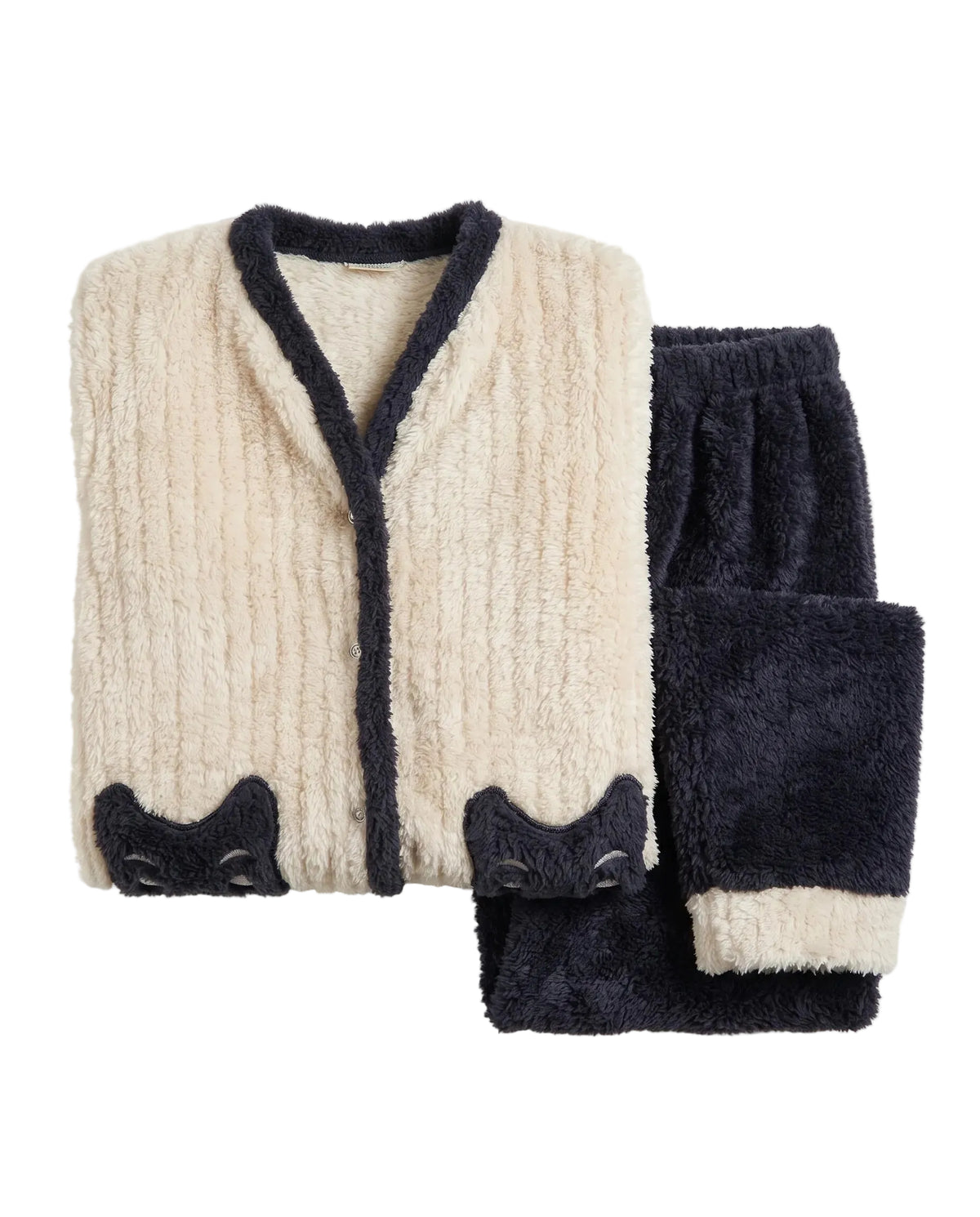 A folded two-piece fleece pajama set on a light beige background. The set includes a cream-colored ribbed cardigan with dark navy trim and matching navy cat-face appliques at the cuffs, paired with dark navy plush pants featuring cream cuffs.