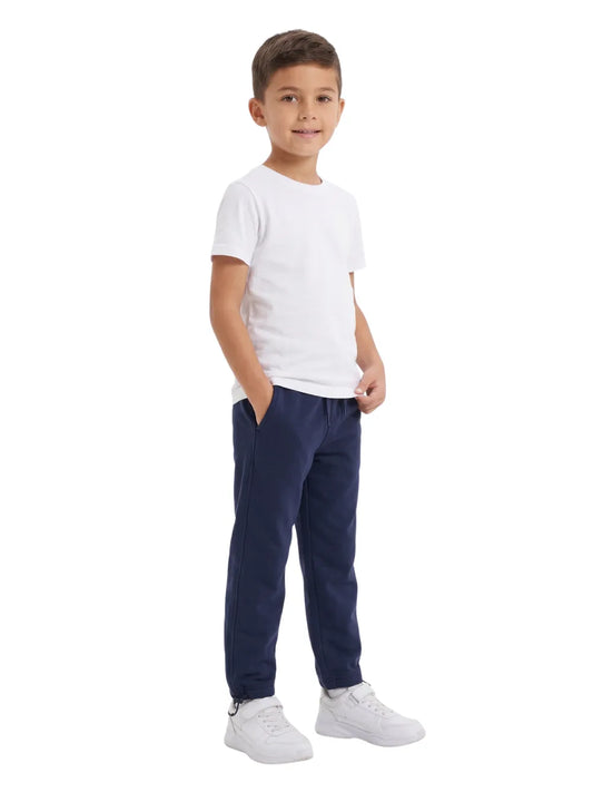 Front view of a young boy wearing solid navy sweatpants and a white t-shirt by TREE