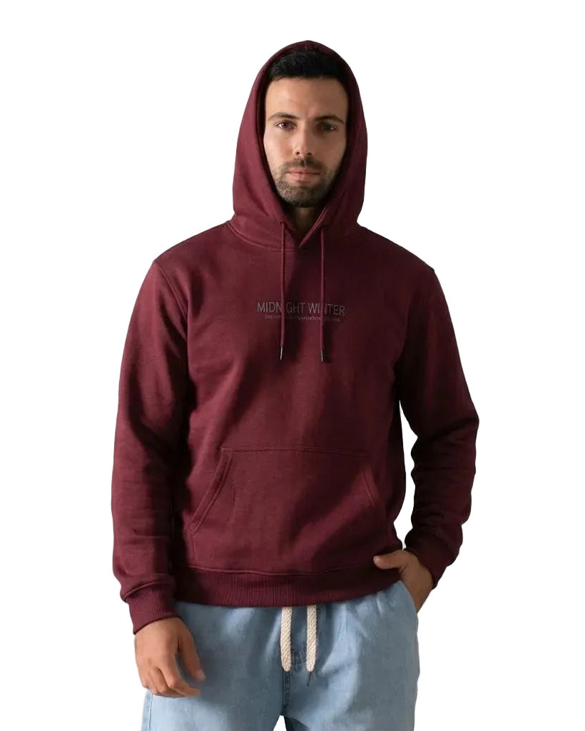 A man wearing a Burgundy pullover hoodie with 'MIDNIGHT WINTER' printed on the chest, paired with light blue sweatpants, against a plain white background.