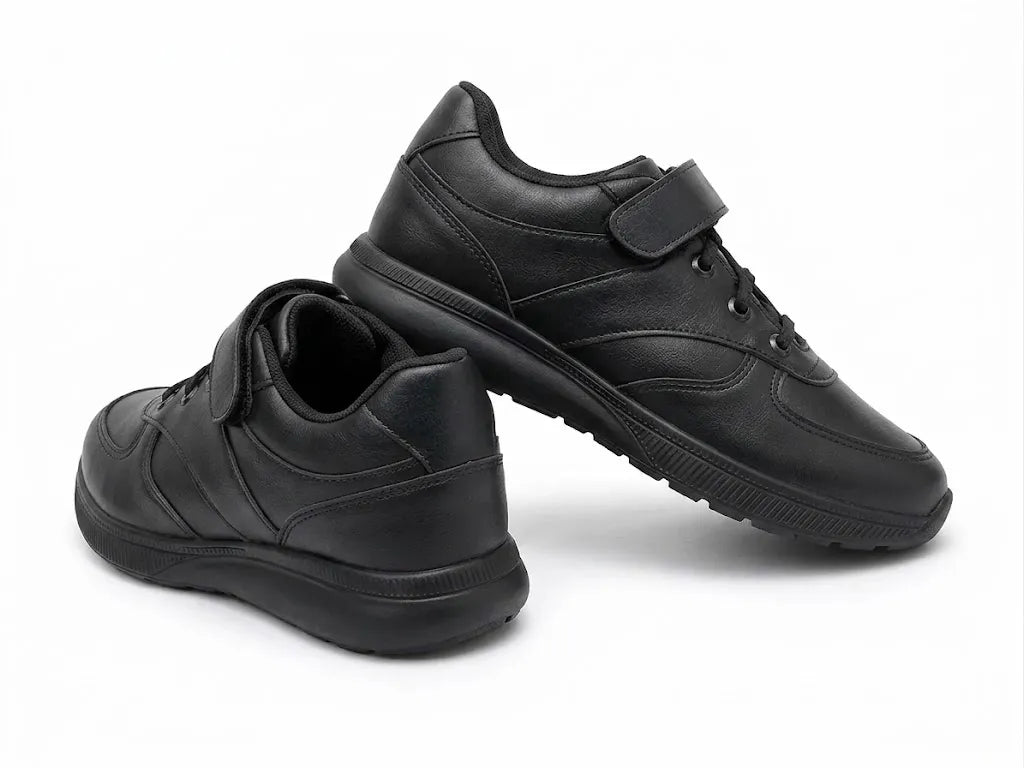 Side view of TREE's black boys' sneakers showing the velcro strap and lace details