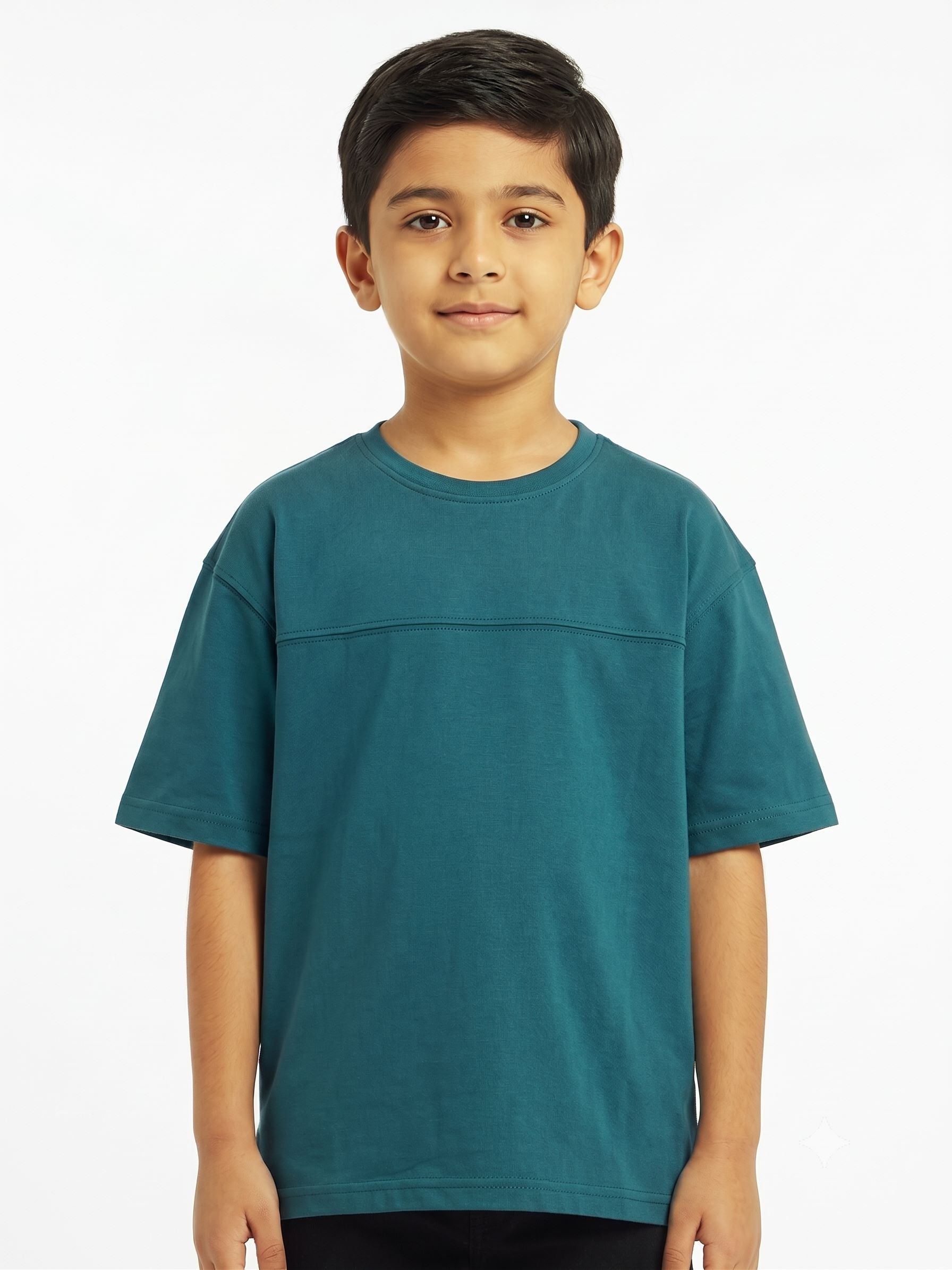 A young boy wearing a teal short-sleeve crewneck t-shirt, standing against a plain white studio background.