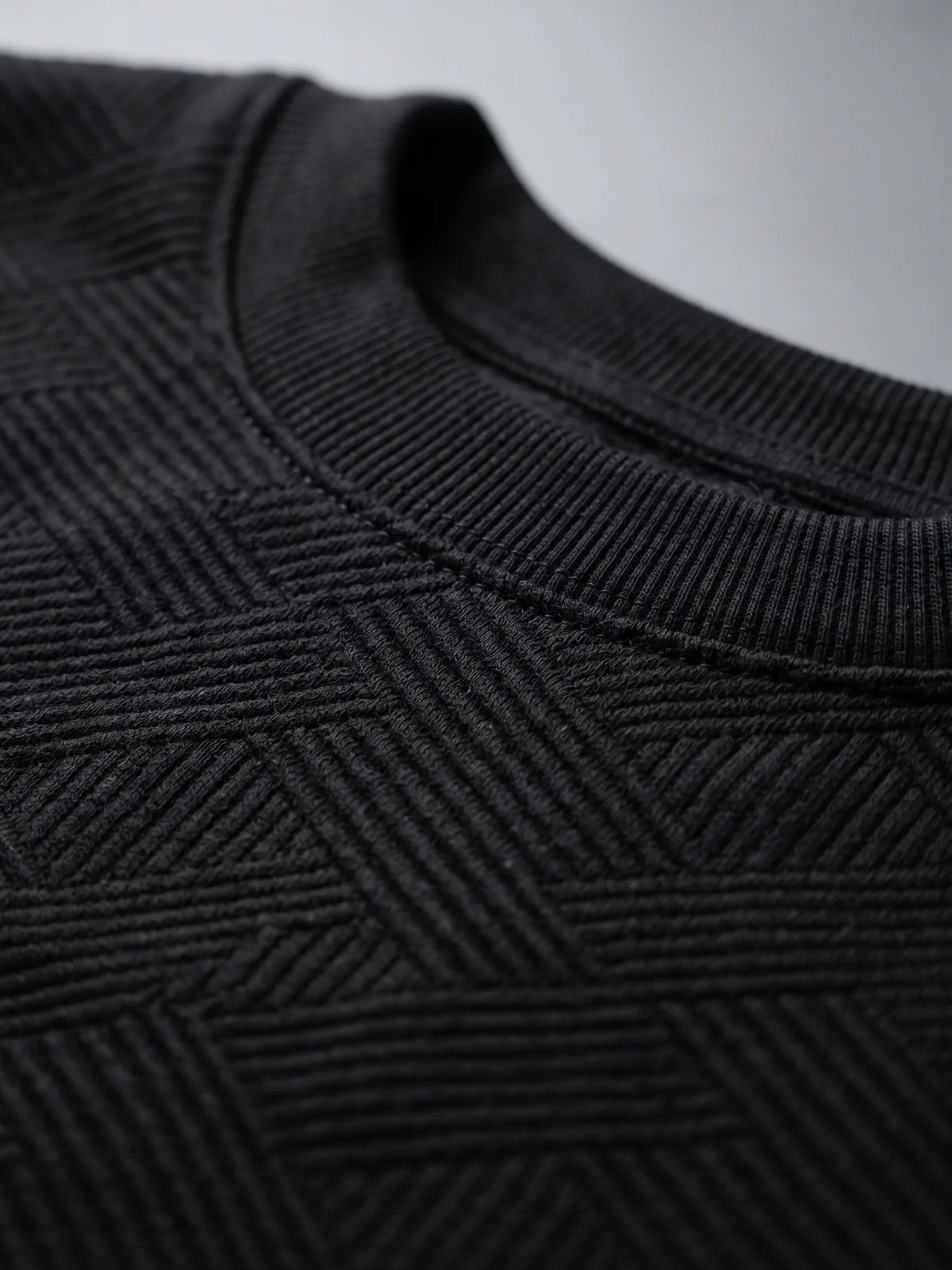 Close-up fabric and collar details of men's black crewneck sweatshirt from TREE