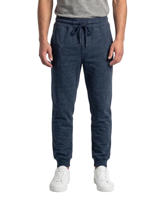 Front view of a man wearing navy slim fit sweatpants by TREE.