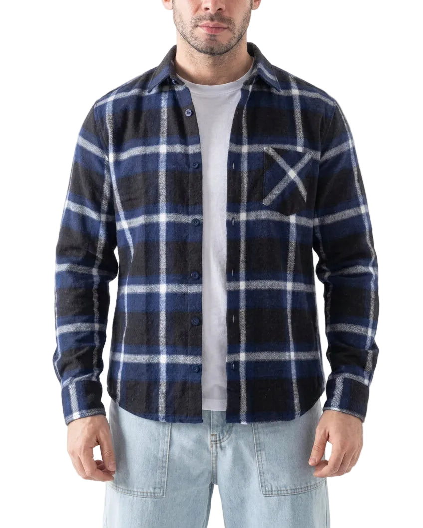 A man wearing a navy blue and black plaid button-up flannel shirt over a white t-shirt and light blue jeans, shown from the waist up against a white background.