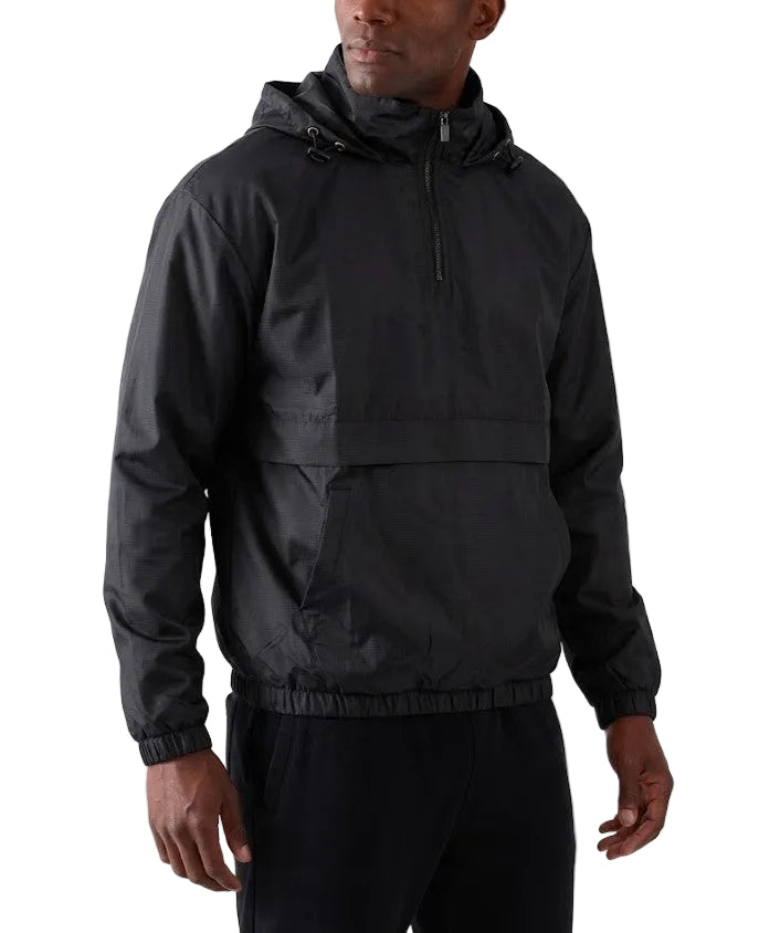 A man wearing a black hooded lightweight jacket with a half-zip front and elastic hem, paired with black pants, photographed against a plain light gray studio background.