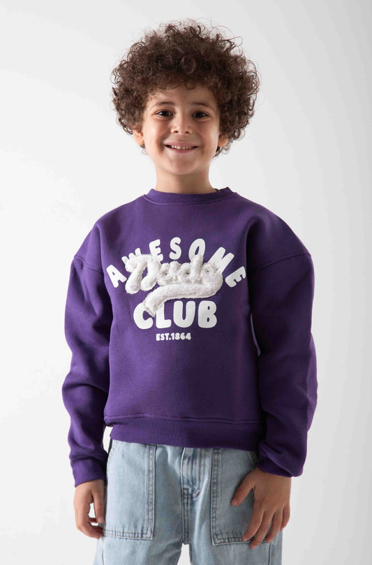 Child wearing a purple sweatshirt with text, standing against a white background