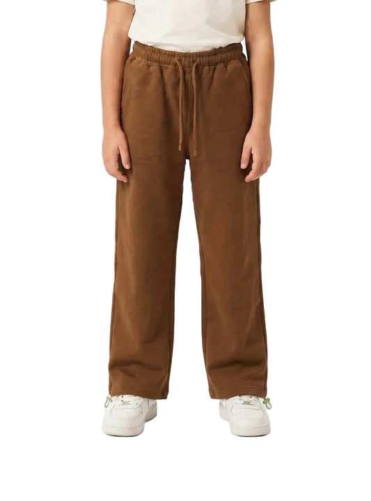 A person wearing brown wide-leg drawstring sweatpants with a cream t-shirt and white sneakers, shown from the waist down against a plain white studio background.