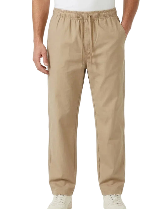 A person wearing beige drawstring pants with a relaxed straight-leg fit, paired with white sneakers, shown from the waist down against a plain white studio background.